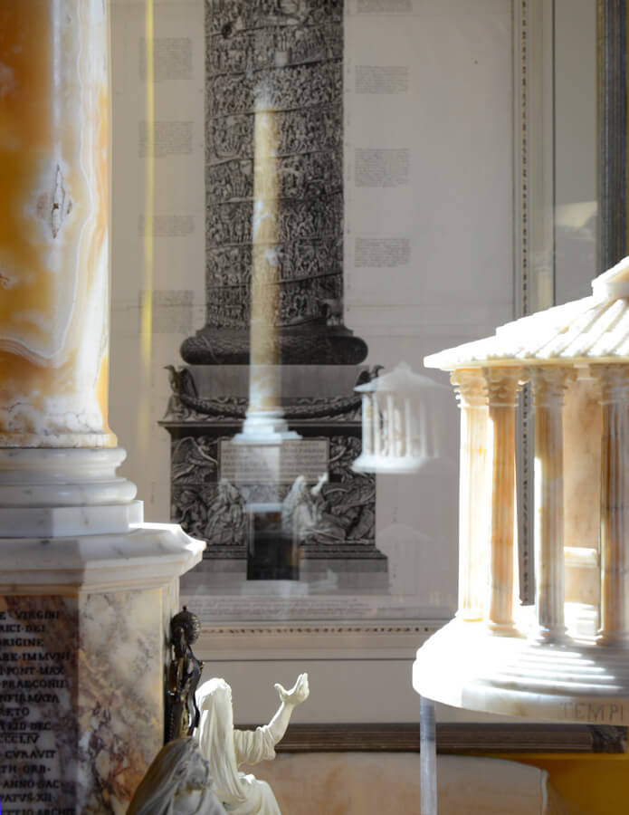 In PIraneseum's Grand Tour Model Gallery, alabaster temples, and a variety of marble replicas are shown against a background of Piranesi prints.